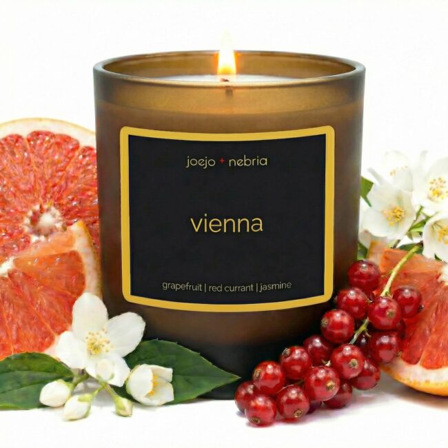 Vienna scented candle by JoeJo + Nebria in amber glass jar with grapefruit, red currant, and jasmine