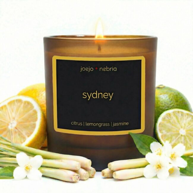 Sydney scented candle by JoeJo + Nebria in amber glass with citrus, lemongrass, and jasmine