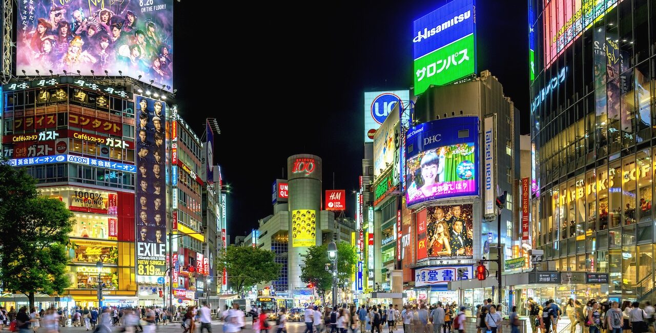 Shibuya Crossing Tokyo at night with neon lights, crowds, and illuminated billboards