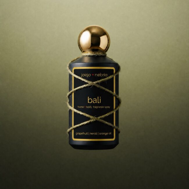 JoeJo + Nebria Bali Home + Body Fragrance Spray featuring grapefruit, neroli, and orange oil fragrance notes, wrapped in natural rope detailing against a soft green gradient background.